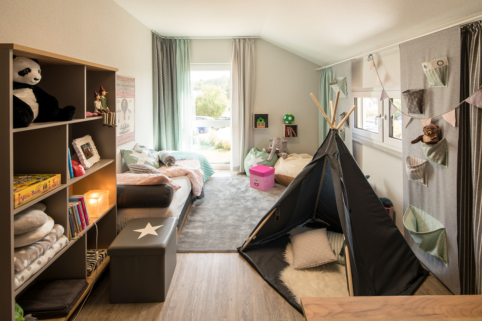 Ejemplo de habitación infantil unisex de 4 a 10 años contemporánea con paredes beige, suelo de madera en tonos medios y suelo marrón