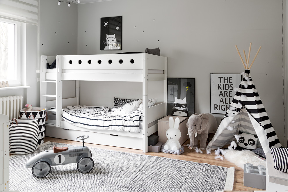 Neutrales Nordisches Kinderzimmer mit Schlafplatz, grauer Wandfarbe und hellem Holzboden in Berlin