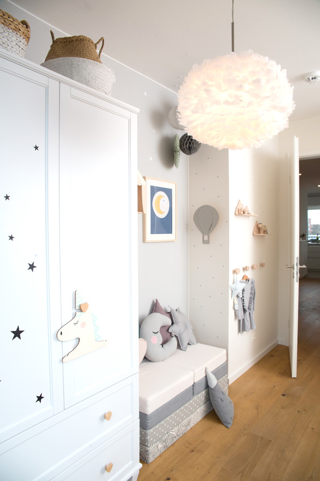 ハンブルクにある高級な中くらいな北欧スタイルのおしゃれな子供部屋 (グレーの壁、無垢フローリング、ベージュの床) の写真