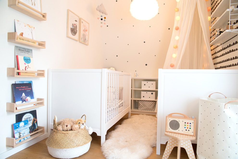 Diseño de habitación infantil unisex escandinava de tamaño medio con paredes blancas, suelo de madera pintada y suelo marrón