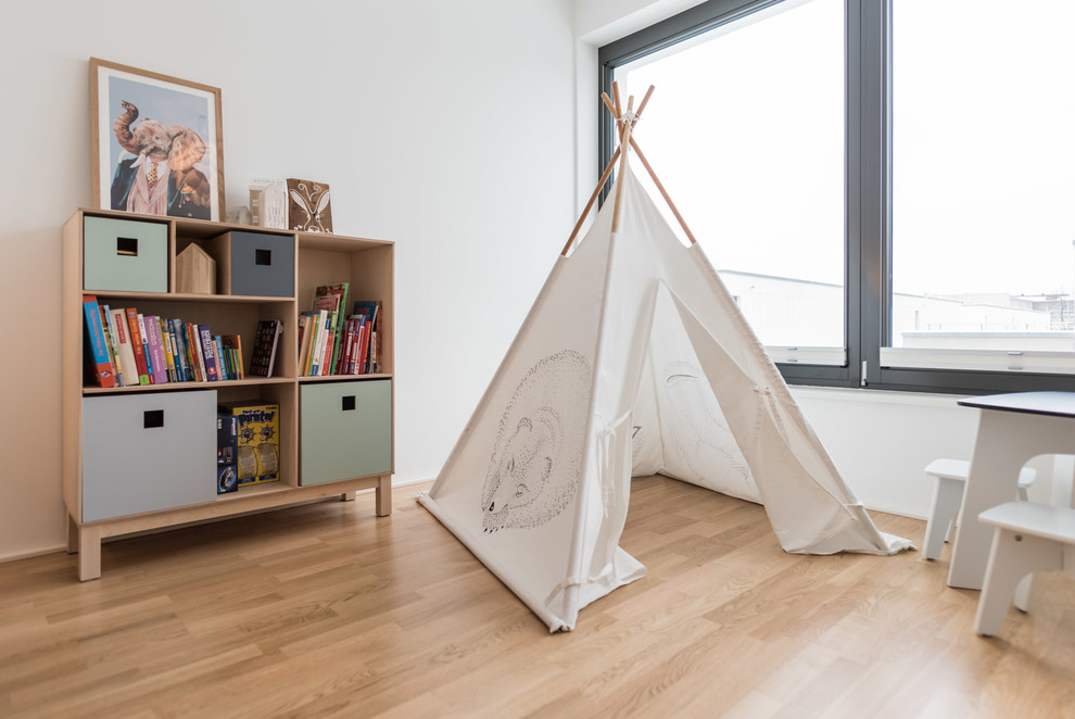 Kleines, Neutrales Skandinavisches Kinderzimmer mit Spielecke, weißer Wandfarbe, braunem Boden und braunem Holzboden in Berlin