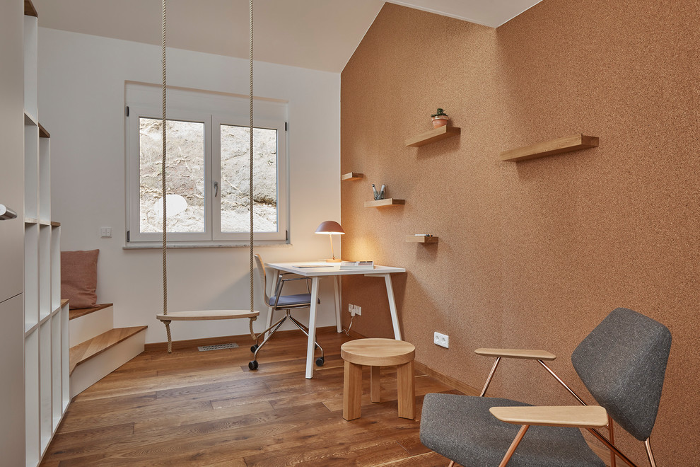 Imagen de dormitorio infantil minimalista pequeño con suelo de madera en tonos medios, escritorio, paredes blancas y suelo marrón