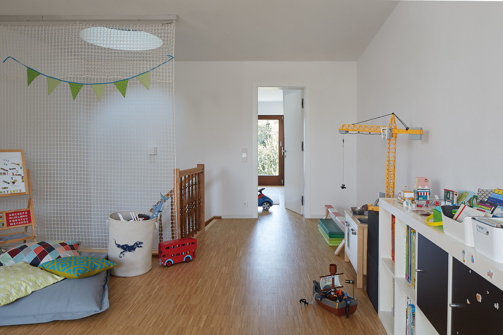Idee per una grande cameretta per bambini da 4 a 10 anni minimalista con pareti bianche e parquet chiaro