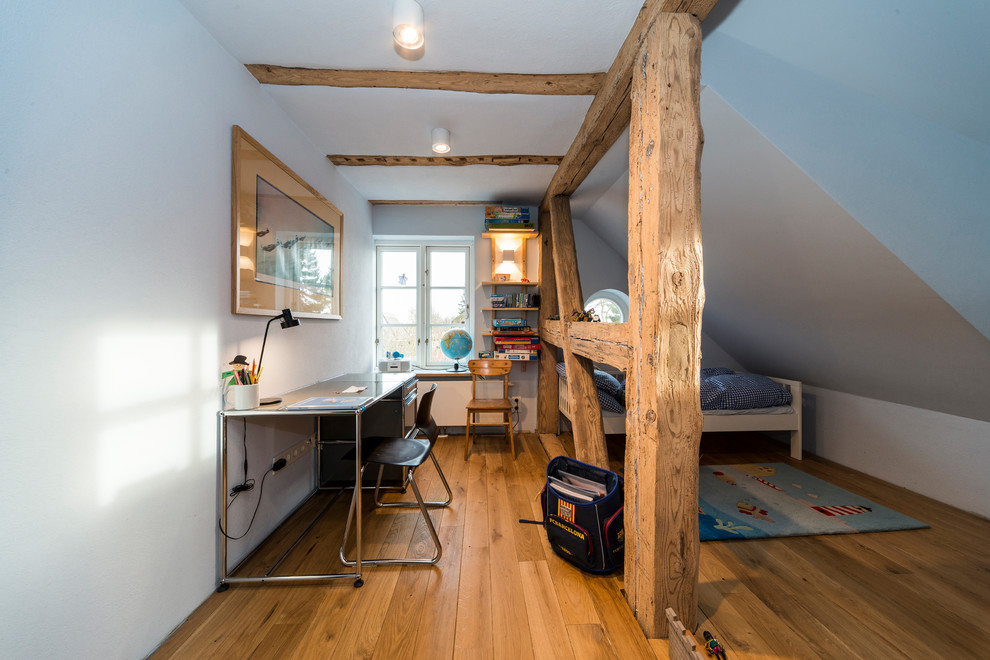 Exemple d'une chambre de garçon de 4 à 10 ans nature de taille moyenne avec un sol en bois brun, un sol marron, un bureau et un mur blanc.