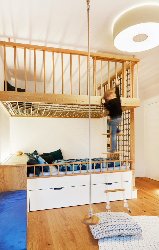 Idéer för funkis pojkrum kombinerat med sovrum och för 4-10-åringar, med vita väggar, mellanmörkt trägolv och brunt golv