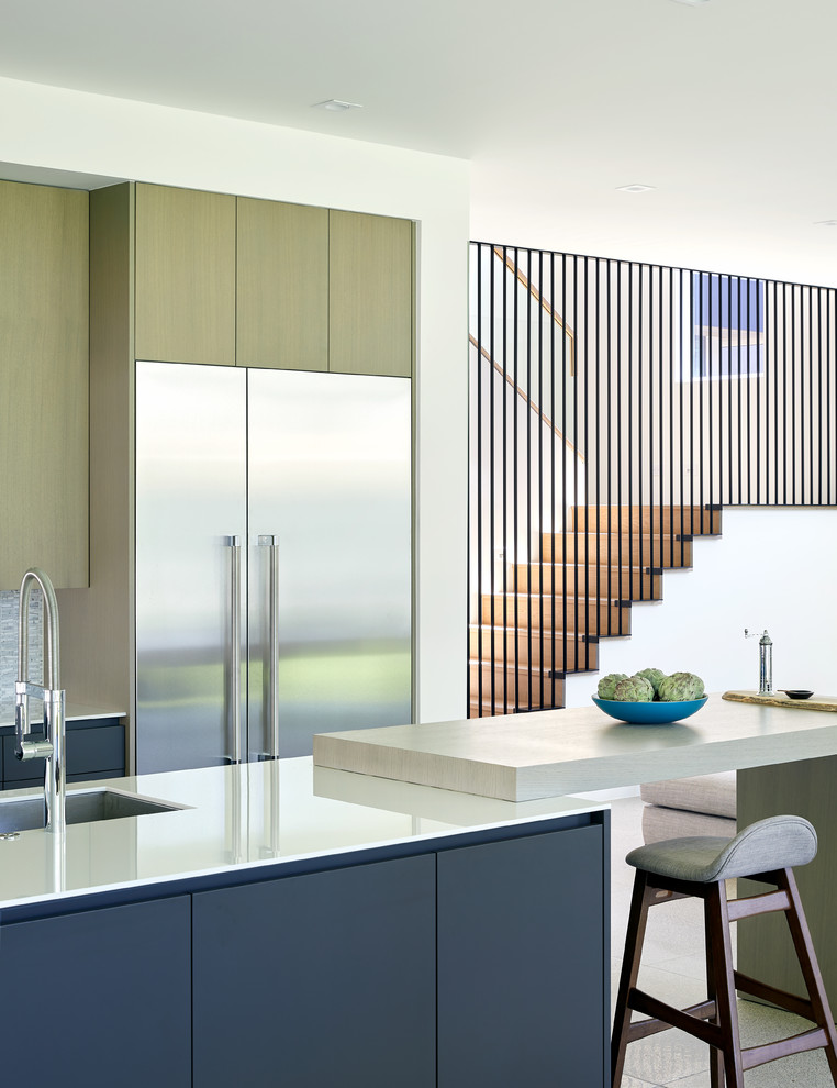 Contemporary galley kitchen in Austin with a submerged sink, flat-panel cabinets, blue cabinets, grey splashback, mosaic tiled splashback, stainless steel appliances, an island, grey floors and white worktops.