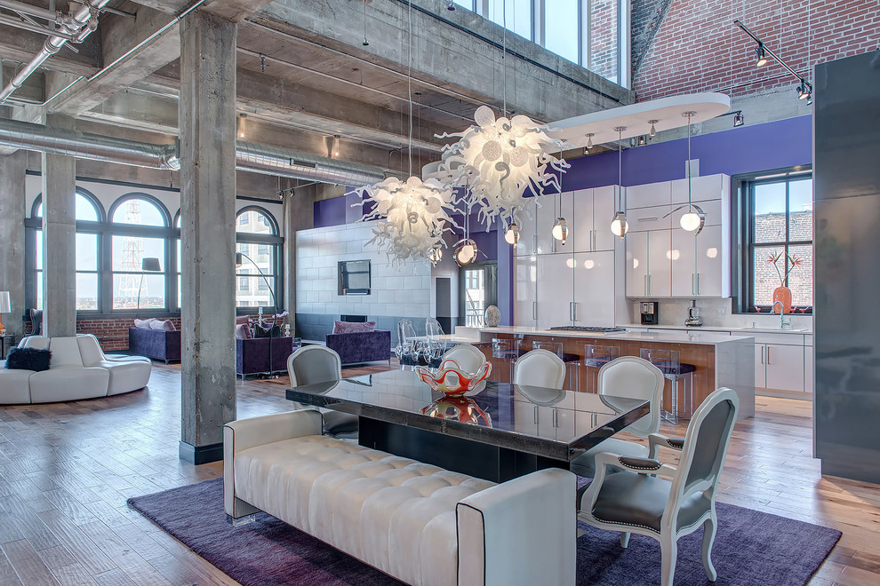 Open concept kitchen - large industrial l-shaped medium tone wood floor and brown floor open concept kitchen idea in St Louis with flat-panel cabinets, white cabinets, paneled appliances and an island