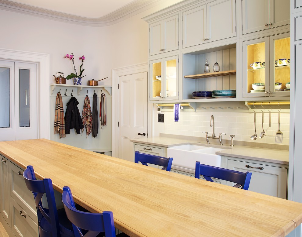 Zweizeilige, Mittelgroße Klassische Wohnküche mit Doppelwaschbecken, Schrankfronten im Shaker-Stil, grünen Schränken, Quarzwerkstein-Arbeitsplatte, Rückwand aus Keramikfliesen, weißen Elektrogeräten, braunem Holzboden und Kücheninsel in Surrey