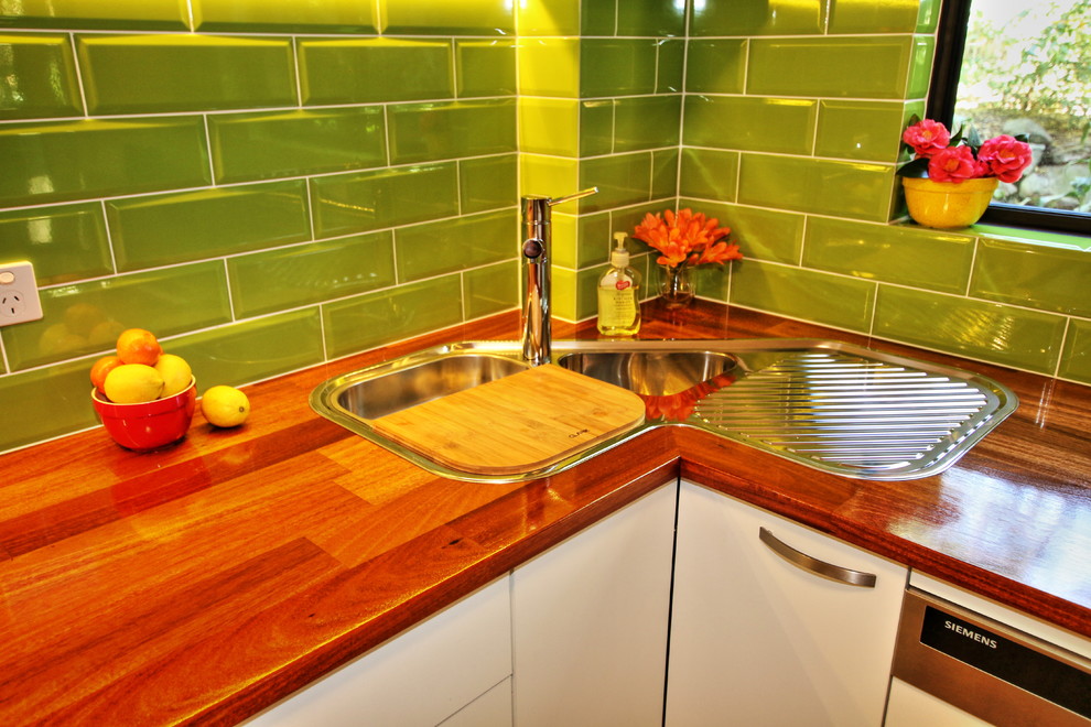 Small trendy u-shaped light wood floor eat-in kitchen photo in Sydney with a drop-in sink, flat-panel cabinets, light wood cabinets, wood countertops, green backsplash, subway tile backsplash, stainless steel appliances and a peninsula
