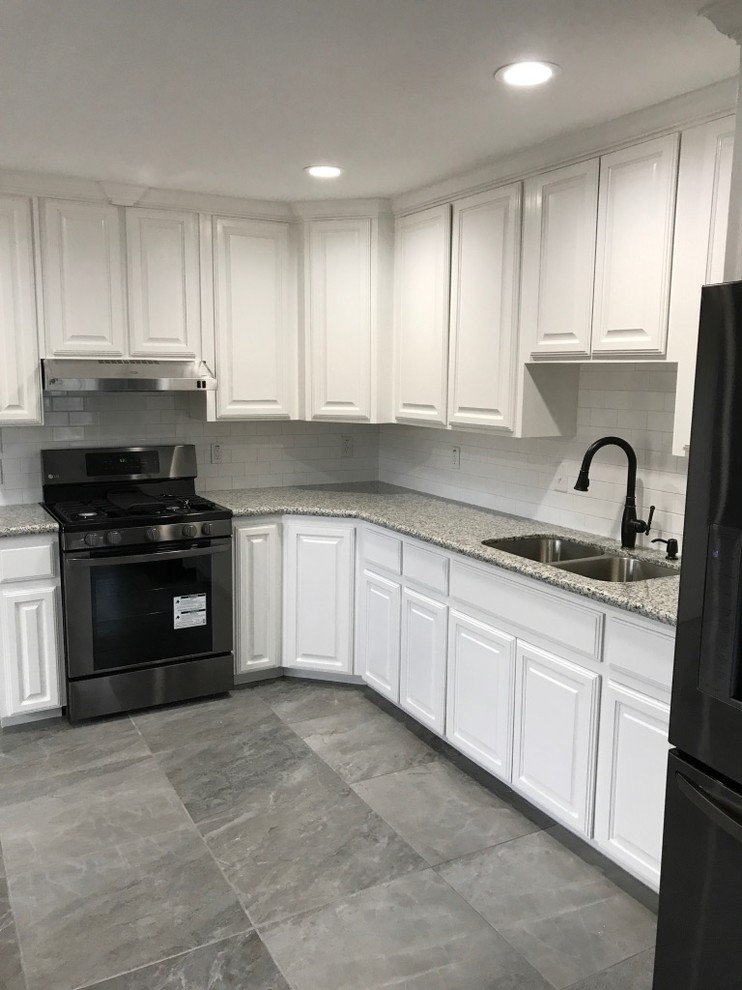 Elegant l-shaped ceramic tile eat-in kitchen photo with an undermount sink, flat-panel cabinets, white cabinets, granite countertops, stainless steel appliances and no island