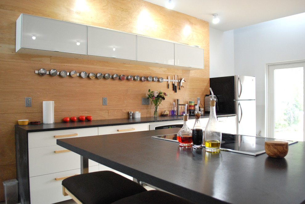 Kitchen - industrial kitchen idea in Philadelphia with solid surface countertops, flat-panel cabinets and white cabinets