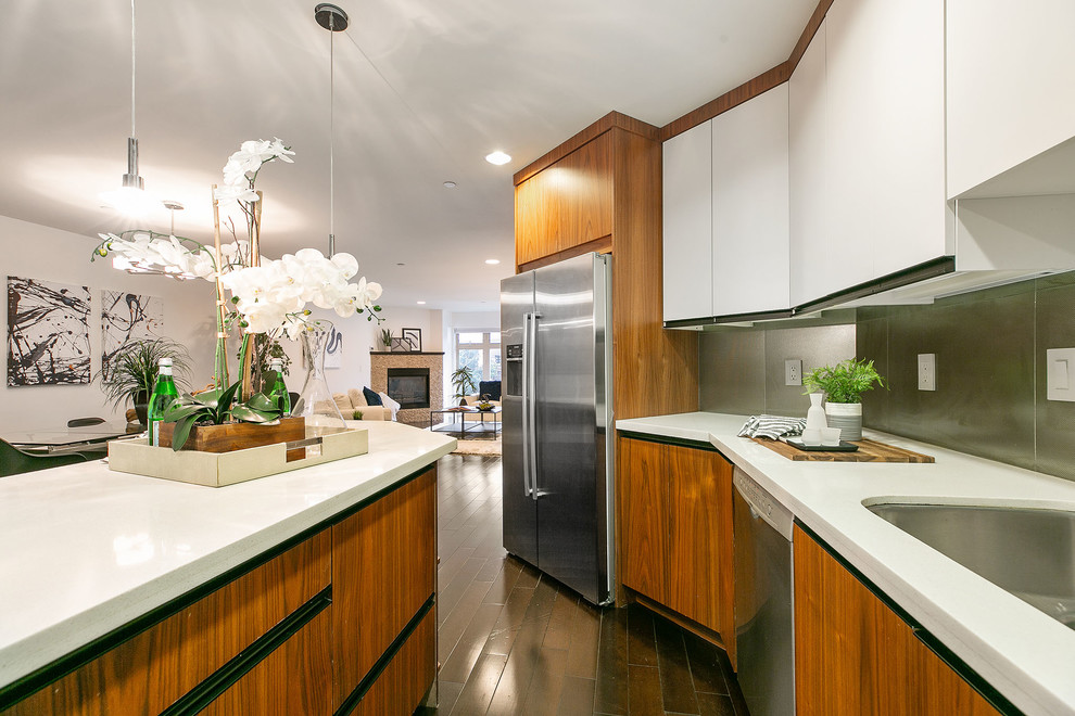 Example of a mid-sized trendy l-shaped dark wood floor and brown floor open concept kitchen design in San Francisco with an undermount sink, flat-panel cabinets, white cabinets, quartz countertops, metallic backsplash, metal backsplash, stainless steel appliances, an island and white countertops