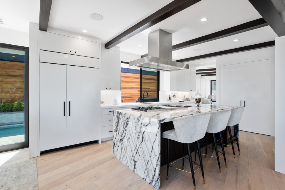 Foto di una cucina design con ante lisce, ante bianche, pavimento in legno massello medio, pavimento marrone, top bianco e travi a vista