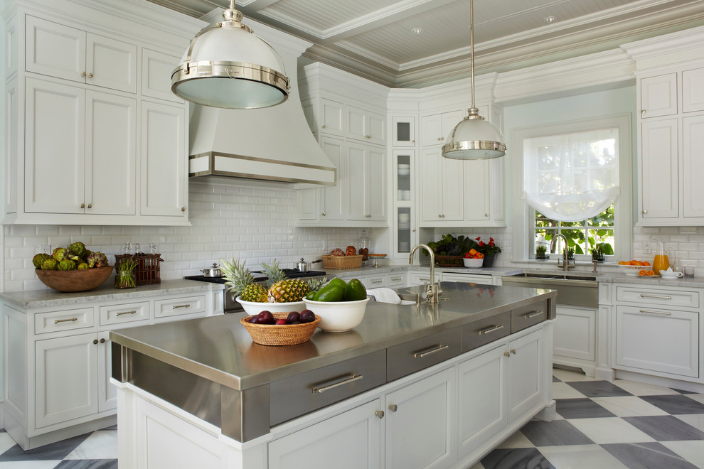 Design ideas for a traditional kitchen in Miami with a belfast sink, beaded cabinets, white cabinets, white splashback, metro tiled splashback, stainless steel appliances and an island.