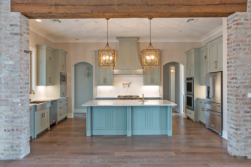 Klassisk inredning av ett kök, med luckor med profilerade fronter, blå skåp, granitbänkskiva och en köksö
