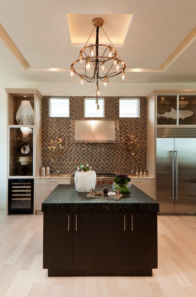 Traditional kitchen in Miami with flat-panel cabinets, light wood cabinets, multi-coloured splashback, stainless steel appliances, light hardwood flooring and an island.