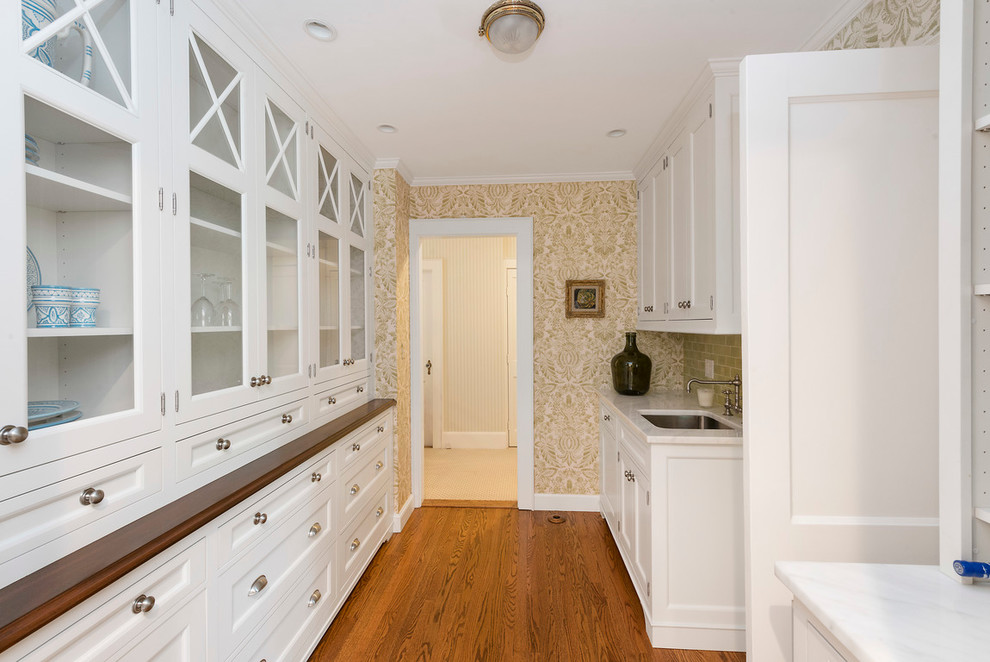 Example of a mid-sized classic medium tone wood floor kitchen pantry design in Boston with recessed-panel cabinets and white cabinets