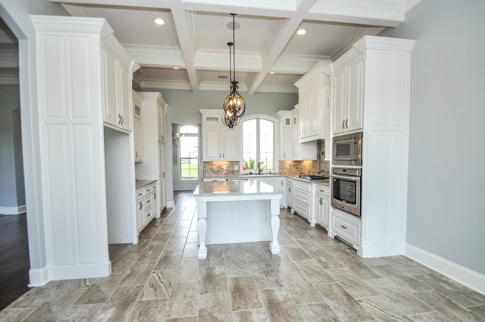 Example of a mid-sized classic u-shaped ceramic tile eat-in kitchen design in New Orleans with a drop-in sink, raised-panel cabinets, white cabinets, granite countertops, gray backsplash, ceramic backsplash, stainless steel appliances and an island
