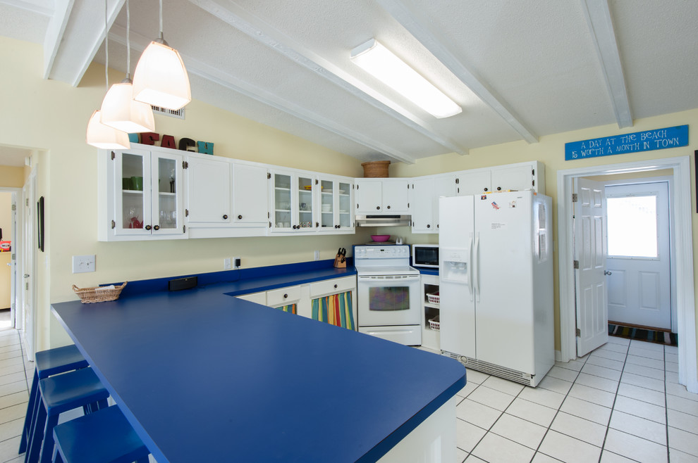 Example of a beach style kitchen design in Miami with blue countertops
