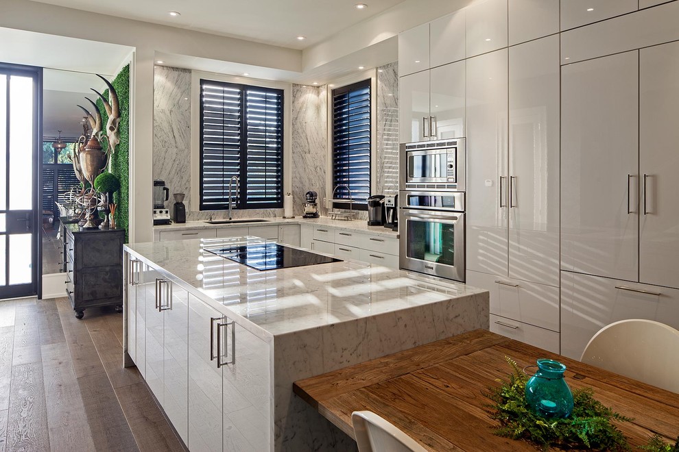 Example of an eclectic l-shaped eat-in kitchen design in Toronto with flat-panel cabinets and white cabinets