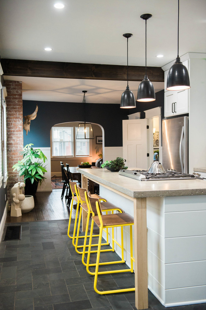 Inspiration for a small eclectic single-wall slate floor and gray floor kitchen pantry remodel in New York with an undermount sink, glass-front cabinets, white cabinets, concrete countertops, white backsplash, ceramic backsplash, stainless steel appliances and an island