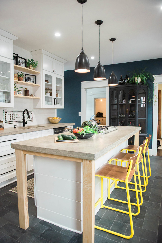 Foto på ett litet lantligt grå linjärt kök, med en undermonterad diskho, vita skåp, bänkskiva i betong, vitt stänkskydd, stänkskydd i keramik, rostfria vitvaror, skiffergolv, en köksö, grått golv och skåp i shakerstil