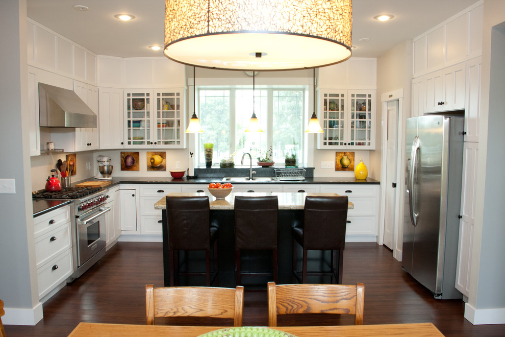 Bild på ett amerikanskt kök, med en dubbel diskho, skåp i shakerstil, vita skåp, laminatbänkskiva, beige stänkskydd, rostfria vitvaror och mörkt trägolv