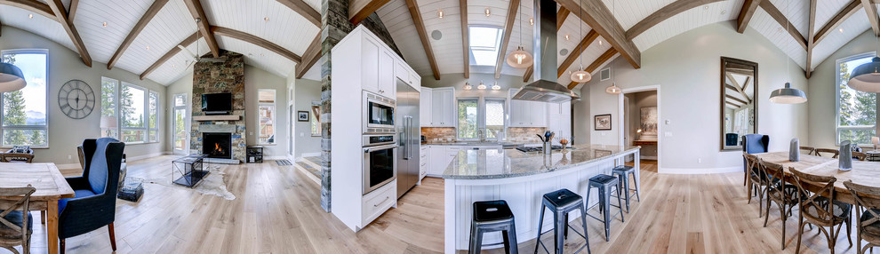 Moderne Küche in L-Form mit Schrankfronten im Shaker-Stil, weißen Schränken, Küchenrückwand in Beige, Küchengeräten aus Edelstahl, hellem Holzboden und Kücheninsel in Denver