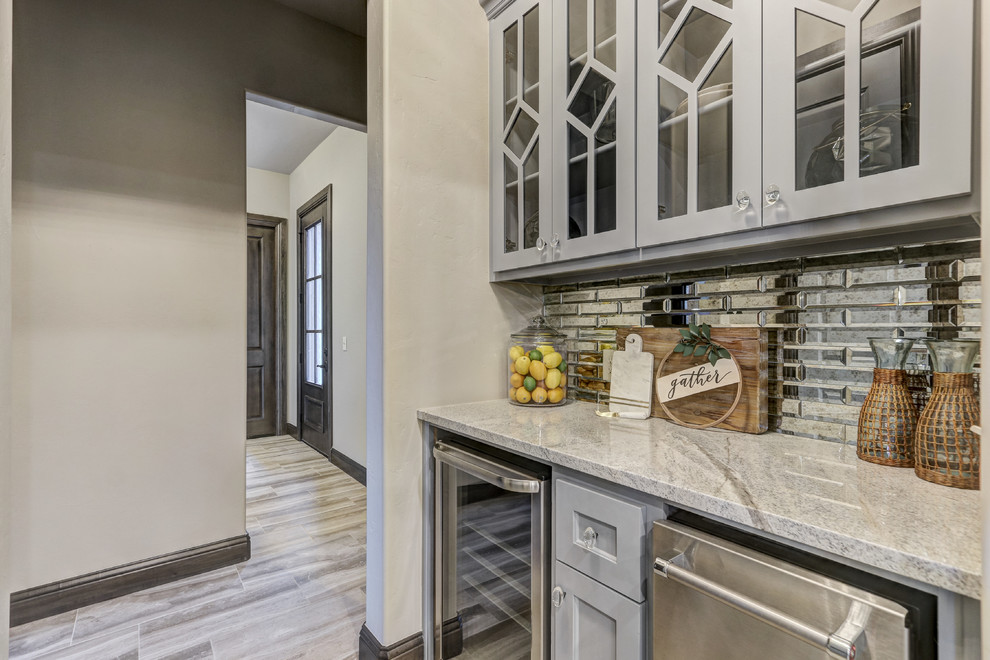 Large transitional l-shaped porcelain tile and beige floor eat-in kitchen photo in Oklahoma City with an undermount sink, shaker cabinets, white cabinets, quartz countertops, multicolored backsplash, porcelain backsplash, stainless steel appliances and two islands