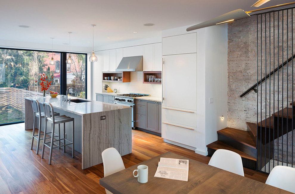 Zweizeilige Moderne Wohnküche mit flächenbündigen Schrankfronten, weißen Schränken und Mauersteinen in New York