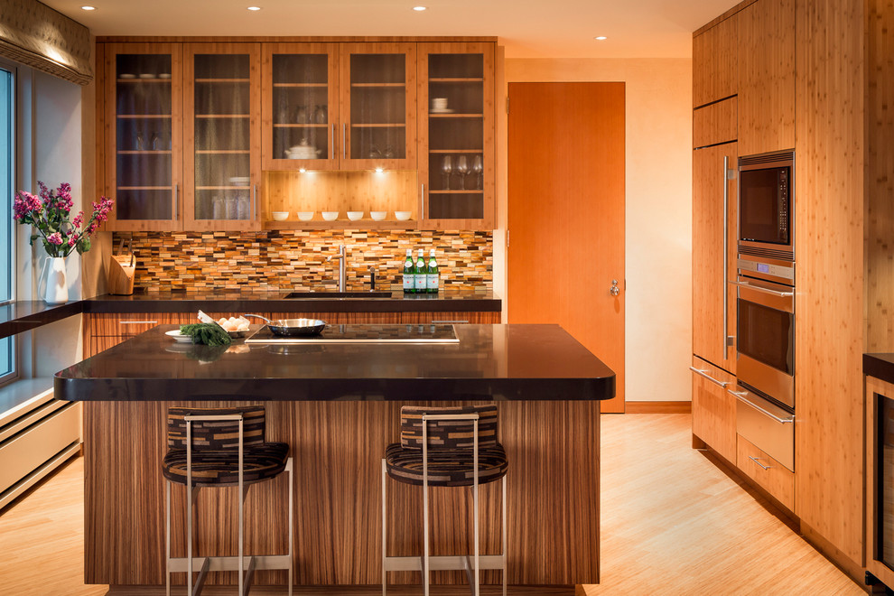 Mid-sized trendy l-shaped bamboo floor open concept kitchen photo in San Francisco with an undermount sink, flat-panel cabinets, medium tone wood cabinets, quartz countertops, multicolored backsplash, glass tile backsplash, paneled appliances and an island
