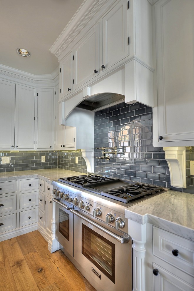 Arts and crafts u-shaped eat-in kitchen photo in Phoenix with beaded inset cabinets, white cabinets, marble countertops, gray backsplash, subway tile backsplash and stainless steel appliances