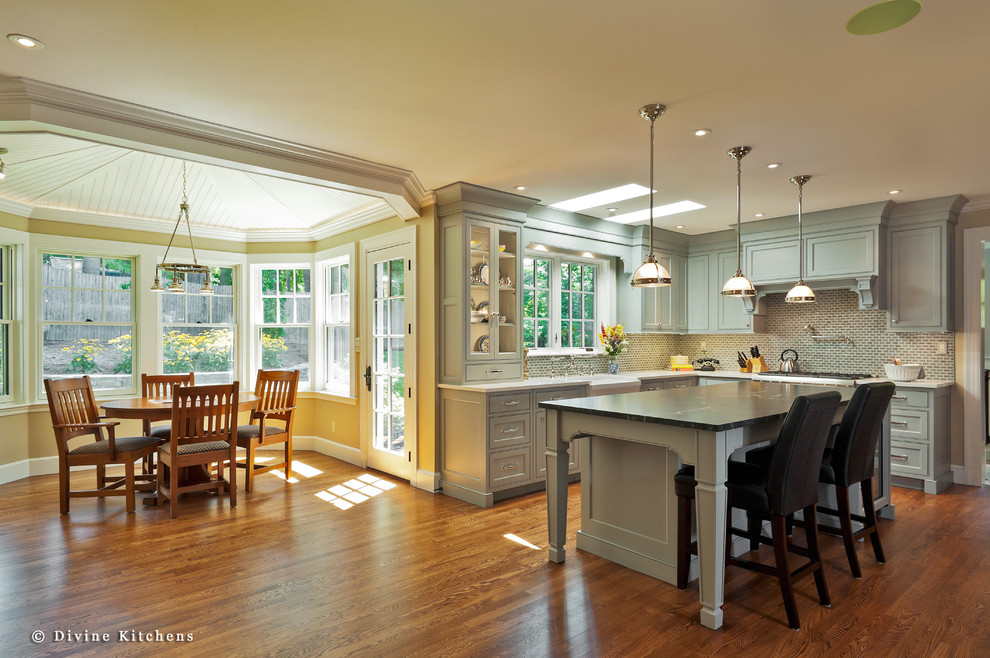 Inspiration for a large transitional u-shaped medium tone wood floor eat-in kitchen remodel in Boston with a farmhouse sink, raised-panel cabinets, white cabinets, beige backsplash, stainless steel appliances and an island
