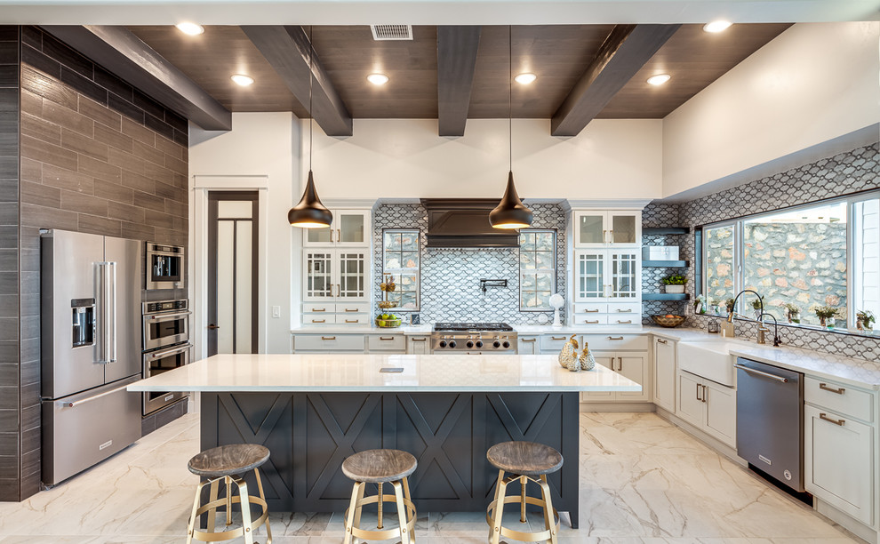 Inspiration for a farmhouse u-shaped kitchen in Austin with a belfast sink, shaker cabinets, white cabinets, grey splashback, stainless steel appliances, an island, white floors and white worktops.