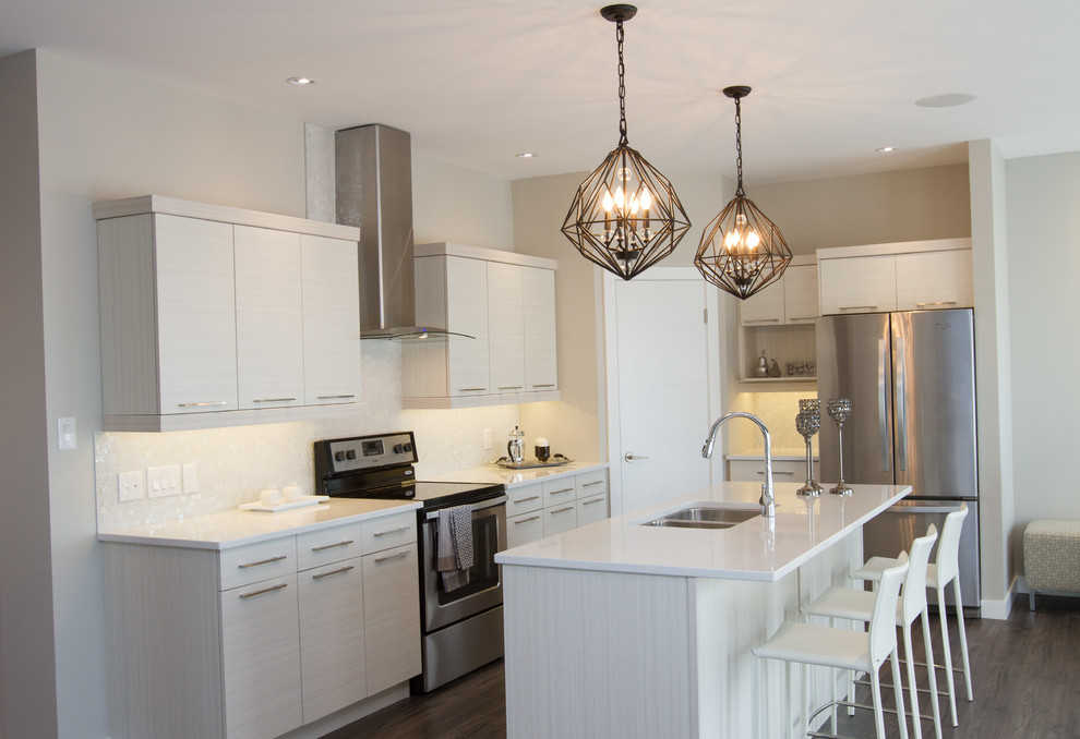 Mittelgroße Klassische Wohnküche in L-Form mit weißen Schränken, Küchenrückwand in Weiß, Küchengeräten aus Edelstahl, braunem Holzboden und Kücheninsel in Sonstige