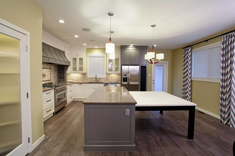 Eat-in kitchen - transitional medium tone wood floor eat-in kitchen idea in Calgary with an undermount sink, shaker cabinets, white cabinets, quartzite countertops, black backsplash, mosaic tile backsplash and stainless steel appliances