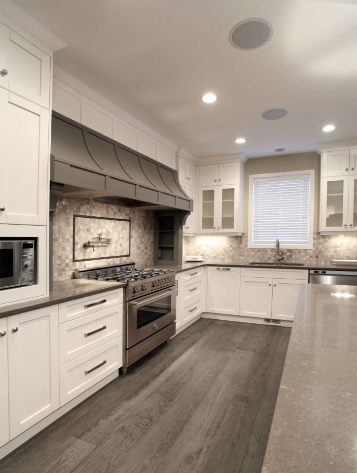 Transitional medium tone wood floor eat-in kitchen photo in Calgary with an undermount sink, shaker cabinets, white cabinets, quartzite countertops, black backsplash, mosaic tile backsplash and stainless steel appliances