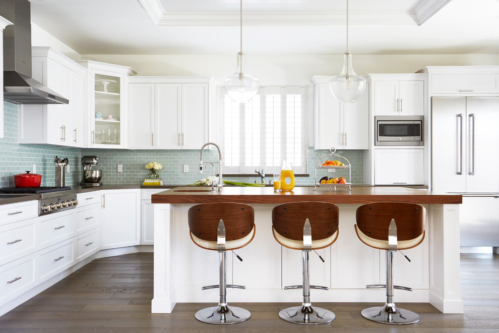 Foto på ett stort vintage kök, med skåp i shakerstil, vita skåp, blått stänkskydd, stänkskydd i glaskakel, rostfria vitvaror, mörkt trägolv, en köksö, brunt golv och träbänkskiva