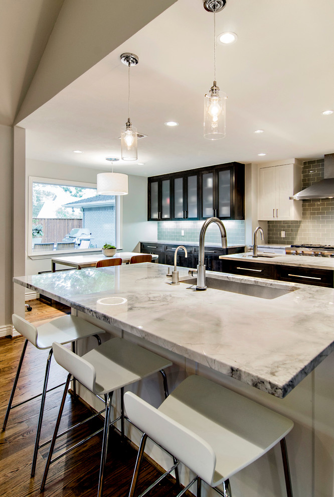 Foto di una cucina chic con lavello sottopiano, ante in stile shaker, ante bianche, top in granito, paraspruzzi grigio, paraspruzzi con piastrelle di vetro e elettrodomestici in acciaio inossidabile