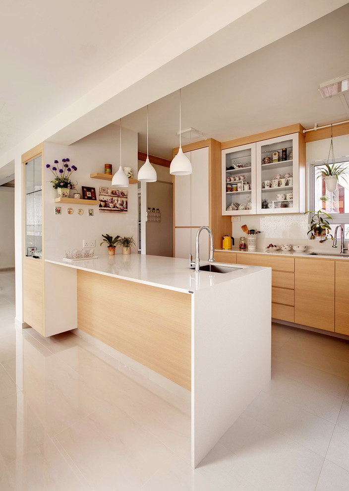 Zweizeilige Moderne Wohnküche mit Unterbauwaschbecken, flächenbündigen Schrankfronten, hellen Holzschränken, Küchenrückwand in Weiß, Elektrogeräten mit Frontblende, Kücheninsel und beigem Boden in Singapur