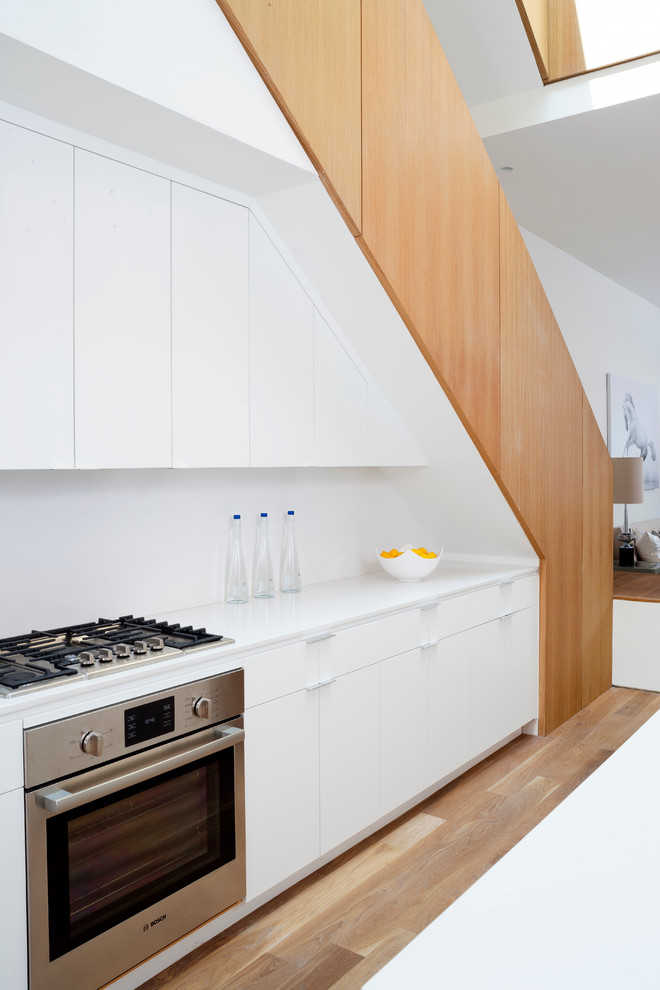 Свежая идея для дизайна: кухня в современном стиле с плоскими фасадами и белыми фасадами - отличное фото интерьера
