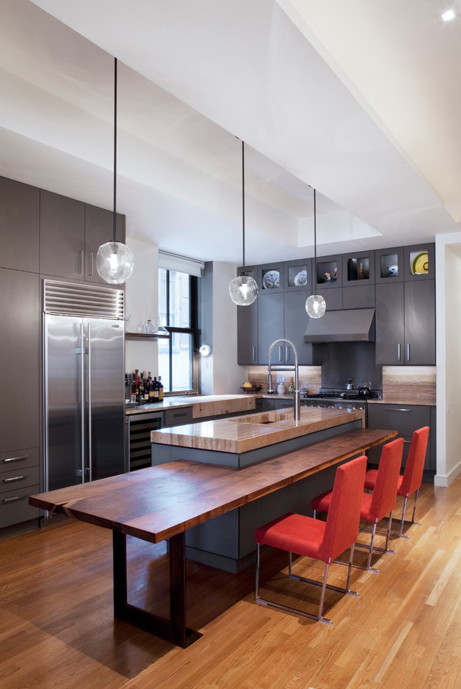 Источник вдохновения для домашнего уюта: угловая кухня в современном стиле с обеденным столом, плоскими фасадами, серыми фасадами и техникой из нержавеющей стали