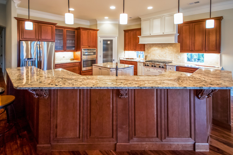 Foto på ett medelhavsstil kök, med en undermonterad diskho, luckor med upphöjd panel, skåp i mellenmörkt trä, granitbänkskiva, rostfria vitvaror och mellanmörkt trägolv