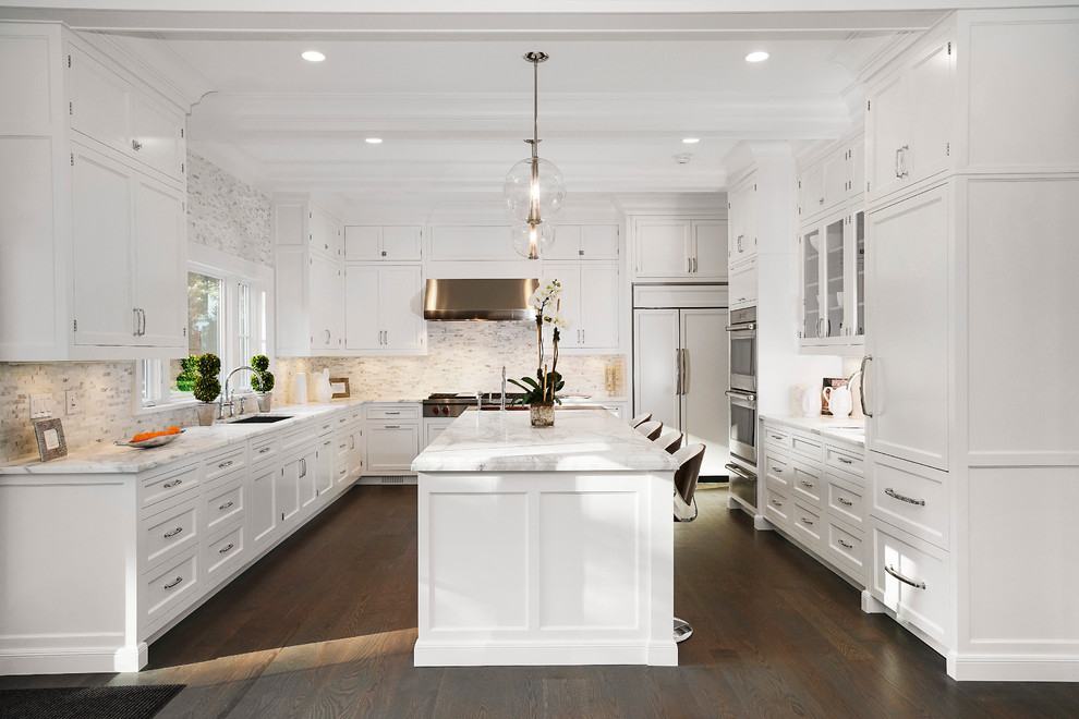 Inspiration för ett mycket stort vintage u-kök, med vita skåp, marmorbänkskiva, integrerade vitvaror, en köksö, en undermonterad diskho, mörkt trägolv och luckor med infälld panel