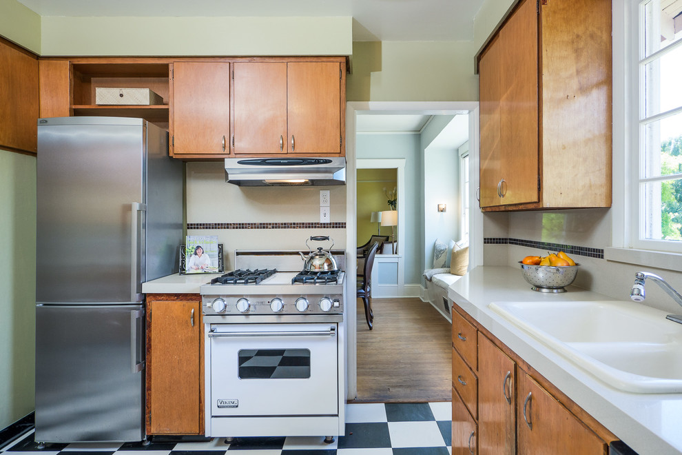Foto di una cucina classica con ante lisce, elettrodomestici bianchi, ante in legno chiaro e lavello da incasso