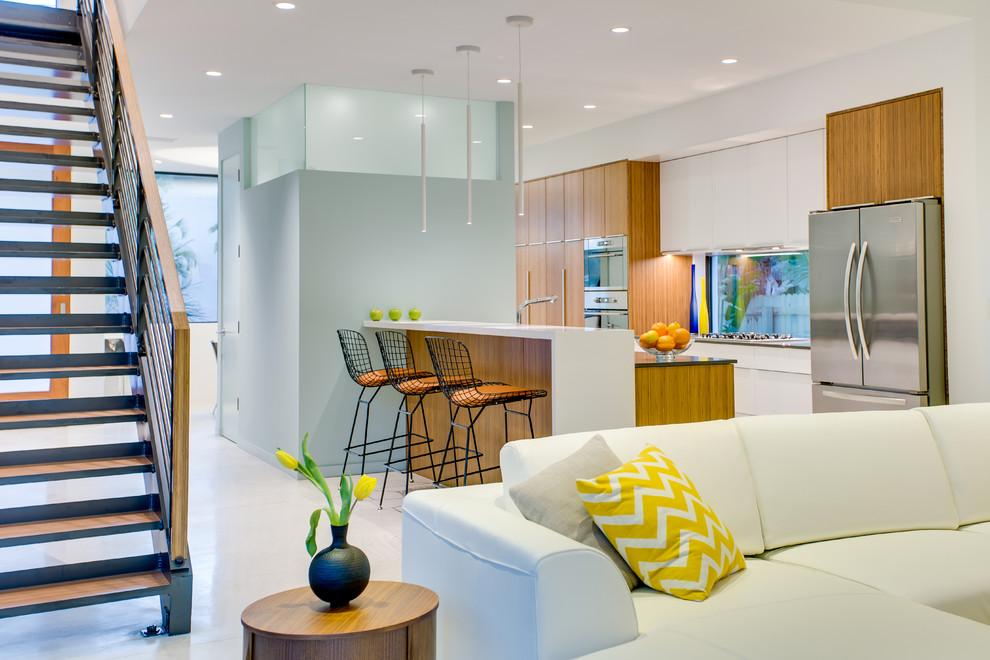 Mid-sized trendy galley porcelain tile open concept kitchen photo in Tampa with flat-panel cabinets, medium tone wood cabinets, an undermount sink, quartzite countertops, stainless steel appliances, no island and window backsplash