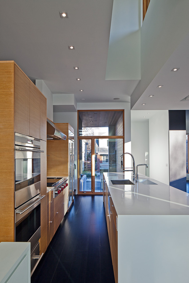 Идея дизайна: параллельная кухня в современном стиле с техникой из нержавеющей стали, плоскими фасадами и фасадами цвета дерева среднего тона