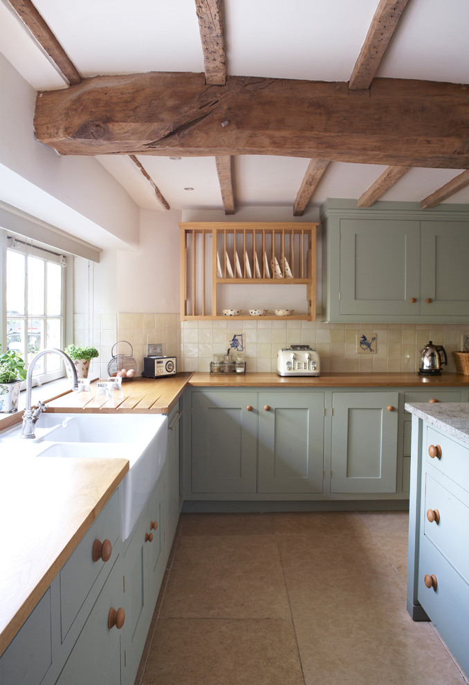 This is an example of a classic kitchen in Devon with an island.