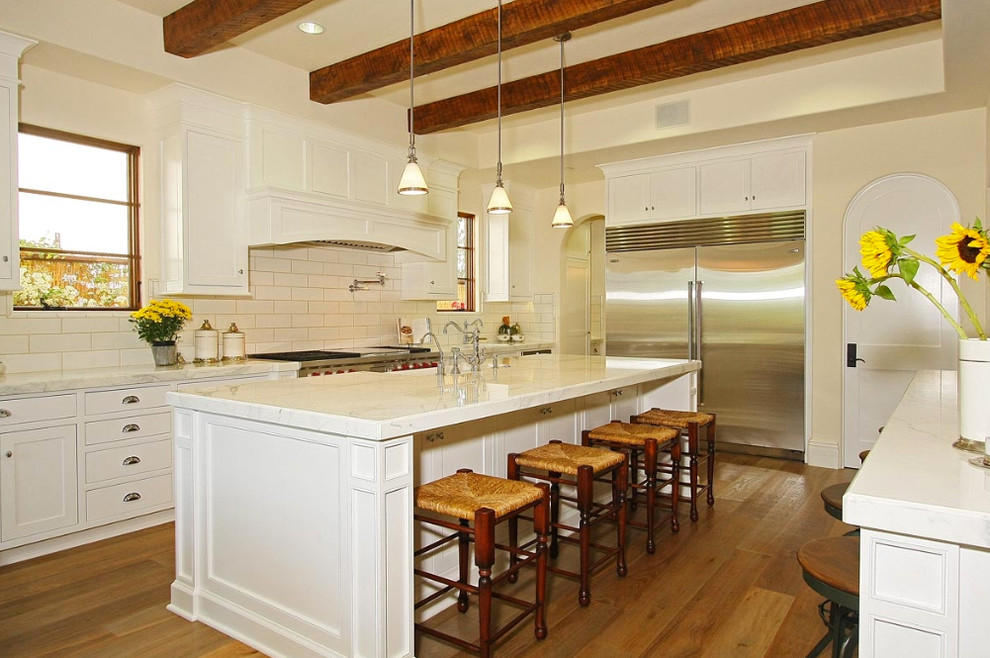 Ejemplo de cocina clásica con electrodomésticos de acero inoxidable y salpicadero de azulejos tipo metro