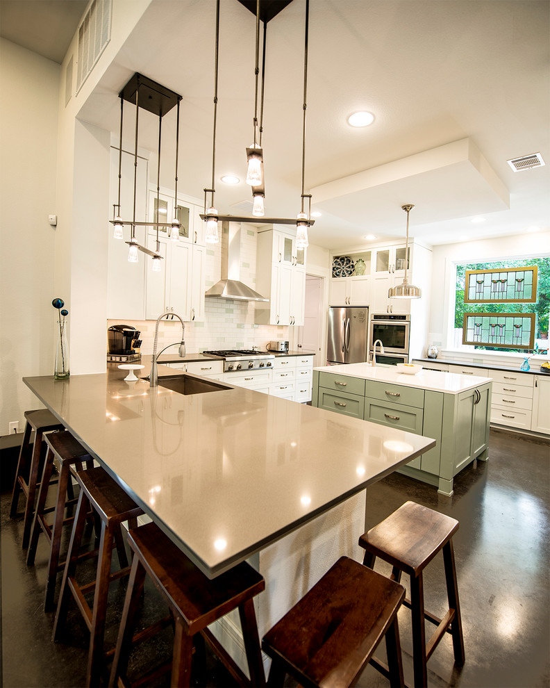 オースティンにあるトランジショナルスタイルのおしゃれなキッチン (シェーカースタイル扉のキャビネット、白いキッチンパネル、サブウェイタイルのキッチンパネル、シルバーの調理設備) の写真